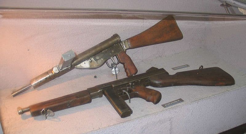 A Thompson Submachine gun (bottom) and a Sten Mk V (top)