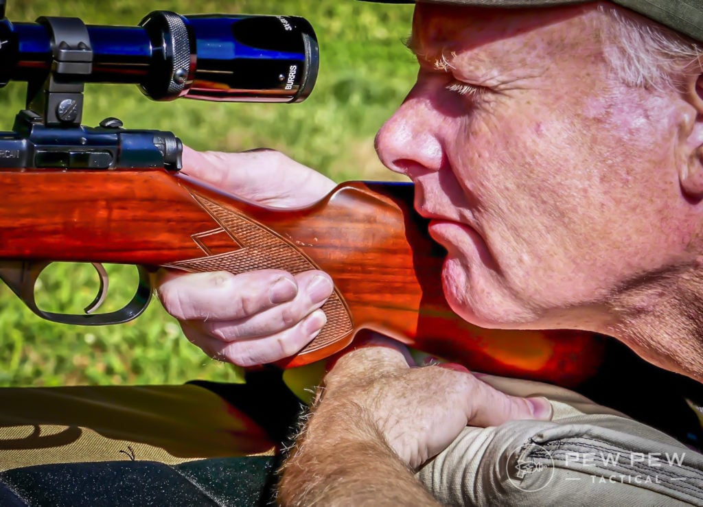 Squeezing your rear bag to adjust your hight and aim while also giving yourself a solid shooting rest.