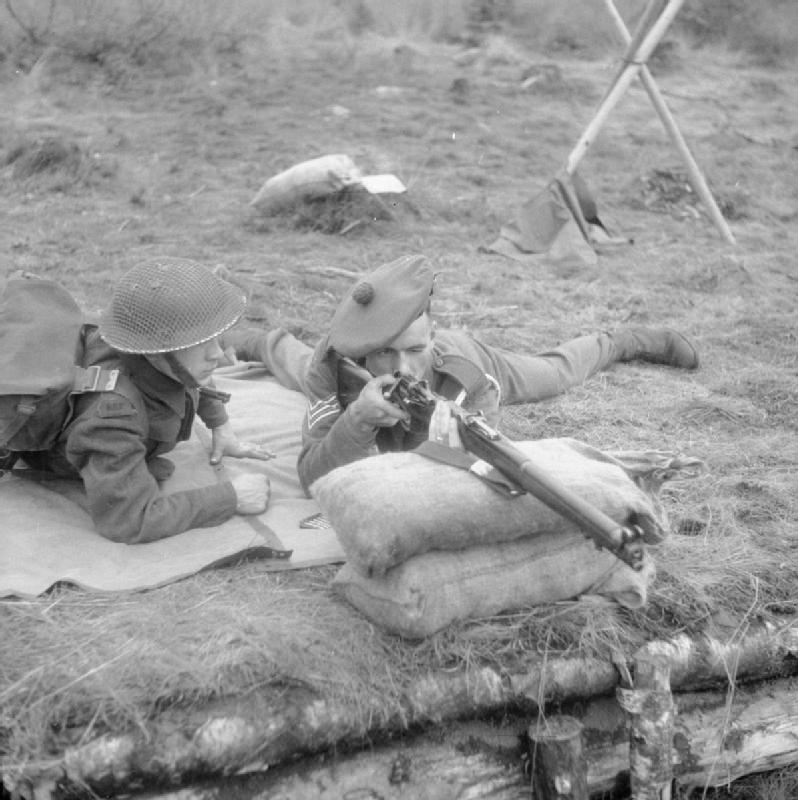 A British sergeant instructor with the Royal Scots Fusiliers trains a recruit on how to fire the SMLE Mk III Lee–Enfield in prone position, 31 August 1942