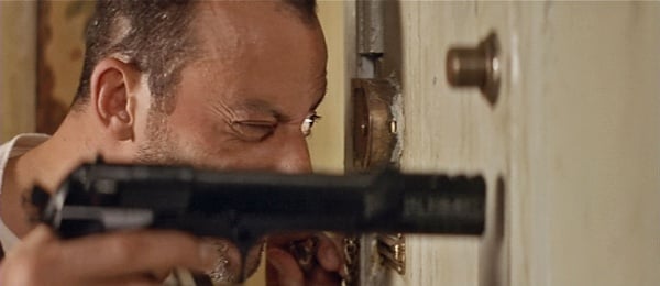 Leon aims his Beretta through a door