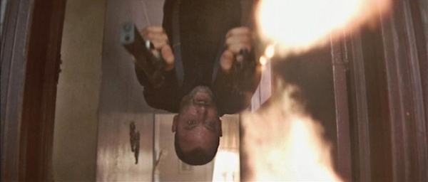 Leon hangs from a doorframe while shooting his pair of Beretta 92FS pistols