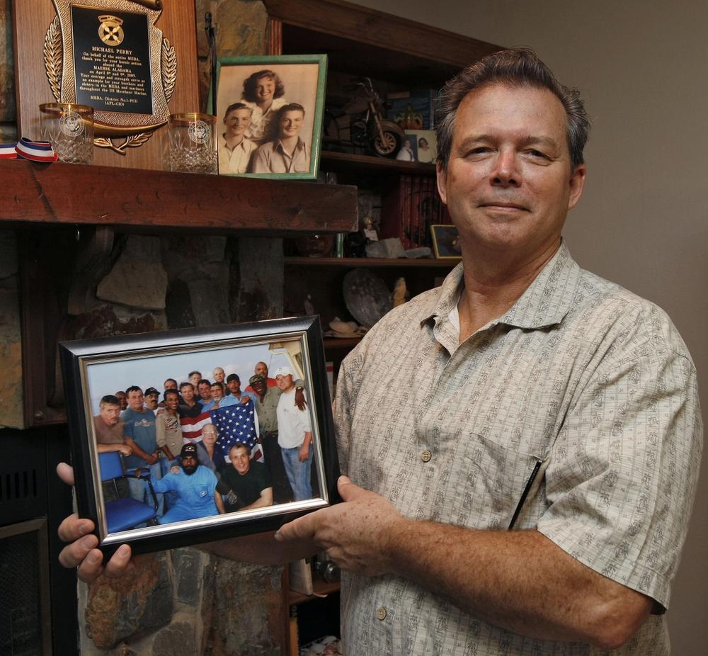 Chief Engineer Mike Perry with a photo of the Alabama's crew