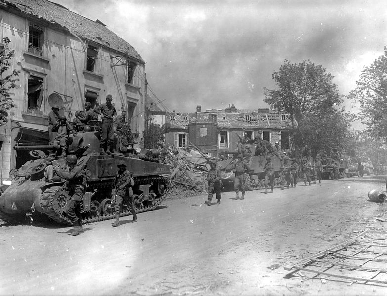 American armored and infantry forces pass through Coutances, France