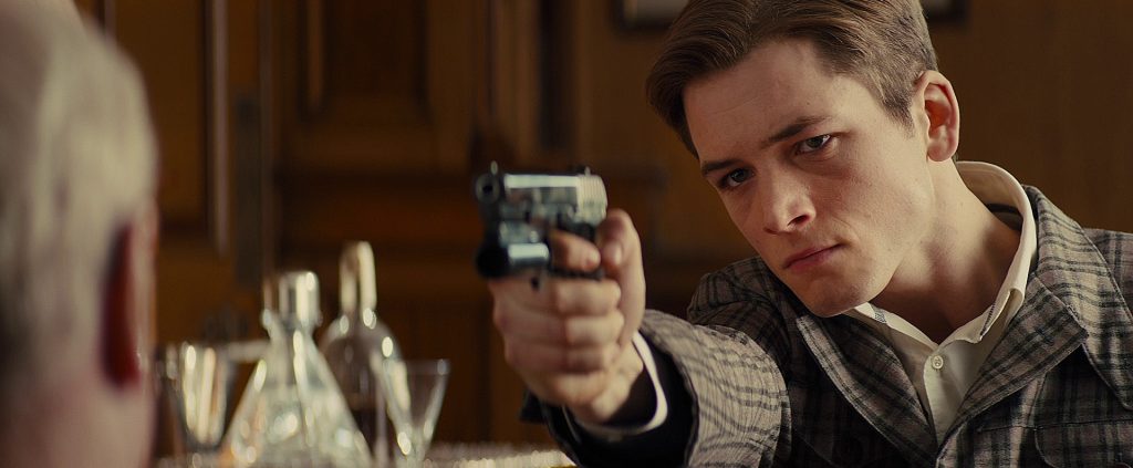 Eggsy (Taron Egerton) with his Kingsman pistol