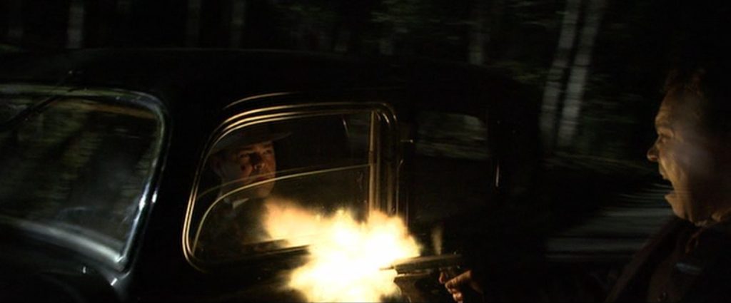 Nelson firing the machine pistol into the car